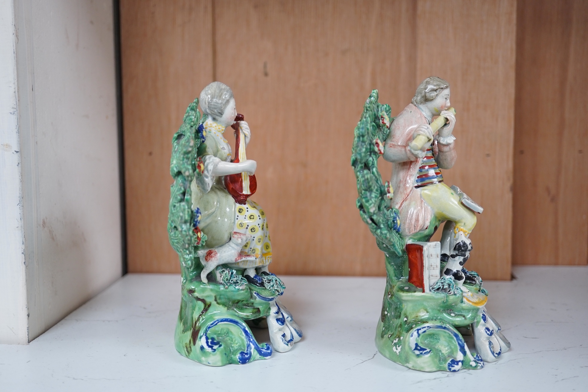 A pair of early 19th century pearlware groups of seated musicians with dogs, 15.5 cm high, Condition - minor faults otherwise fairly good, provenance - sold by Jonathan Horne Antiques